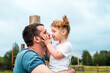 © irishasel - Father andbeautiful baby girl in the village. Sitting high on a wooden fence. Daughter hugs and kisses her father. tender happy family. father's day.