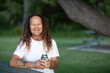 © Caro Telfer/Austockphoto - smiling middle-aged man holding drink outdoors in park