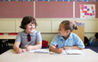 © Claire Bonnor/Austockphoto - Two primary school girls working in a classroom together writing and smiling