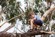 © Clare Farrelly/Austockphoto - Happy kid climbing on fallen gum tree branch