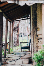 Old Lounge Chair On Porch Of Rustic Bush Property