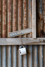 Old Enamel Mug Hanging On Corrugated Iron Wall