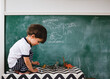 © Maria Manco/Stocksy - boy traces dinosaurs on chalkboard