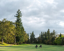 Two Men Walking On Golf Course.