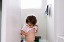 Child Lifts Shirt And Points To Belly