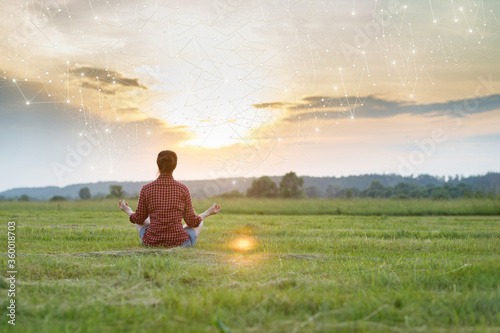Fotografía Woman is recovering in a lotus position against the backdrop of a sunny sunset