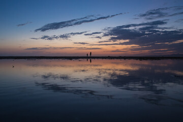 Canvas Print - sunset on Central California beach with human silhouettes reflecting in water