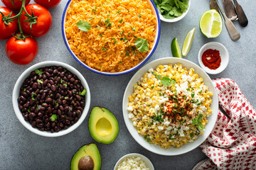 Canvas Print - Mexican food on the table, variety of side dishes, street corn, mexican rice and baked beans