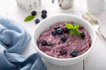 Wall Mural - Blueberry oatmeal for breakfast ith coffee on white table