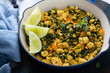 Vegan tofu scramble with spinach and carrots for breakfast with coffee on white table