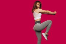 Girl Performs Fitness Exercises On Isolated Pink Background. Girl Playing Sports. Young Girl Performs Stretching Exercises. Sports Girl. Place For An Inscription.