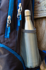 Wall Mural - Metal flask, bottle, thermos inside a mesh pocket of a backpack