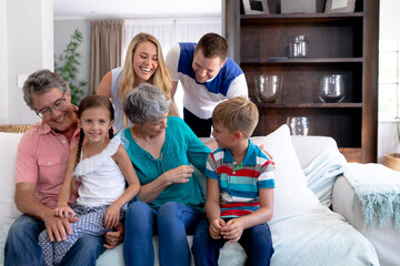 Wall Mural - Portrait of a three generation Caucasian family  sitting on a couch at home