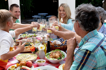 Wall Mural - Caucasian family sitting at table during a family lunch in the garden