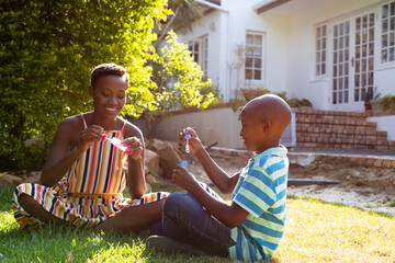 Wall Mural - African American woman and her son, spending time together in the garden