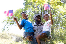 African American Man Wearing A Military Uniform Holding His Children