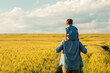 © Masson - father and son in wheat field, child sitting on his fathers shoulders
