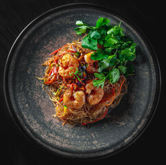 Poster - Stir fry noodles with vegetables and shrimps in plate on wooden table background