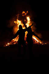 two friends in front of a giant fire