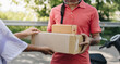 © anut21ng Stock - Delivery man delivering holding parcel box to customer
