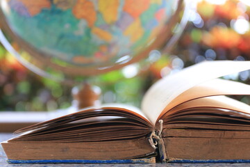 A close up of old books opened Globe as background selective focus and shallow depth of field