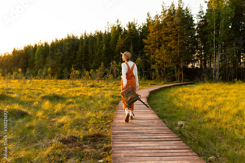 Cuadros en Lienzo Woman botanist with backpack on ecological hiking trail in summer outdoors