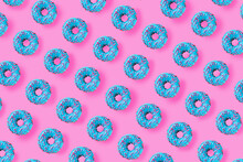 Pattern Of A Blue Donuts On A Bright Pink Background. Flat Lay