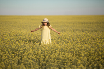 Wall Mural - portrait of a beautiful teenage girl in a hat in a yellow field