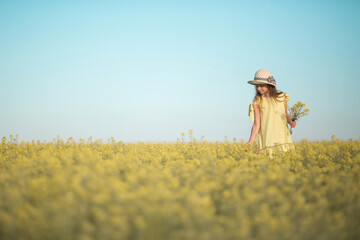 Wall Mural - portrait of a beautiful teenage girl in a hat in a yellow field against the sky