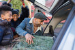 © Sam Edwards/Caia Image - Family loading Christmas tree into car