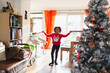 © Sam Edwards/Caia Image - Portrait happy girl in Christmas sweater holding wrapping paper