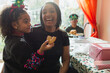 © Sam Edwards/Caia Image - Portrait happy mother and daughter eating Christmas cookie