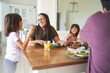© trevor adeline/Caia Image - Happy family eating lunch at table
