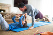 © trevor adeline/Caia Image - Playful father and daughter exercising in living room
