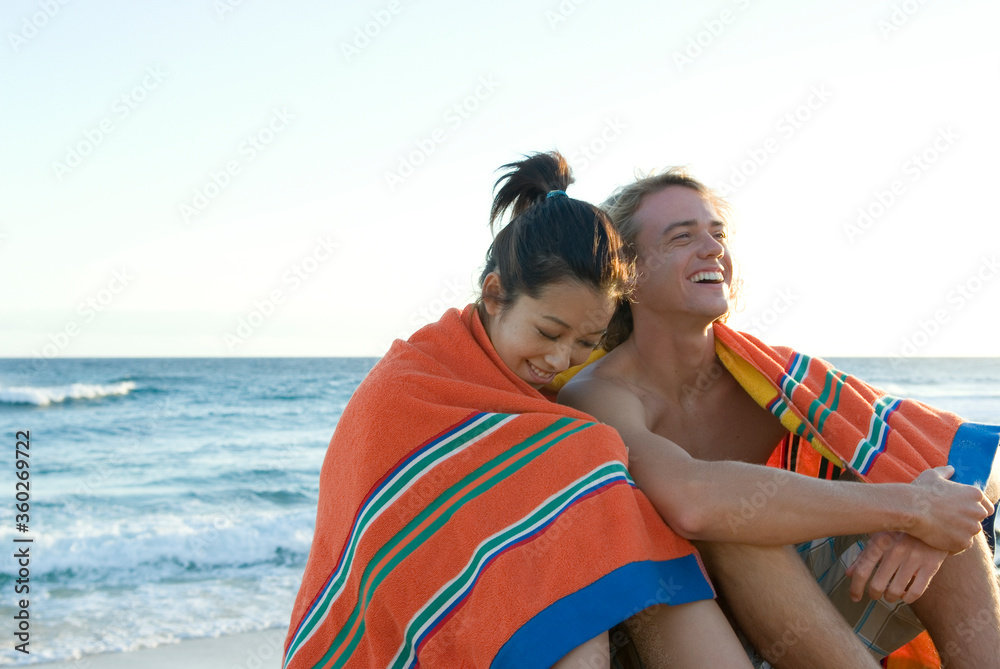 海岸に座る若いカップル