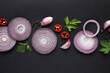 Flat lay composition with slices of onion and spices on black background