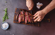 © Anastasia Nurullina/ADDICTIVE STOCK - Male hands cutting cooked until medium ribeye steak on wooden cutting board.