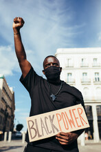 Man Protesting At A Rally For Racial Equality Holding A "Black Power" Poster. Black Lives Matter.