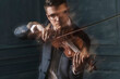 © fStop - Blurred motion of confident violinist playing violin against wall