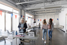 Volunteer And Voters In American Polling Place