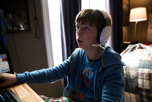 Close Up Of Teen Boy Wearing Headphones Playing Gaming Computer