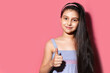 © Lalandrew - Studio portrait of child girl showing thumb up on background of pastel pink of color.