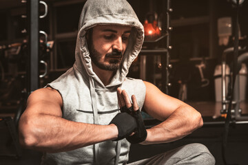 A bearded sporty man in the gym is meditating in a lotus position. Yoga mental benefits.