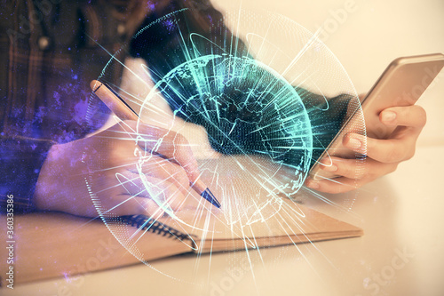 Fotografía Double exposure of business theme sketch hologram and woman holding and using a mobile device
