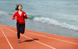 © sunti - Beautiful women wearing red shirts, jogging on the beach.