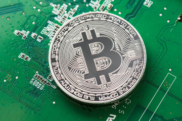 Canvas Print - Silver Bitcoin on green chipset. Close-up, macro shot.