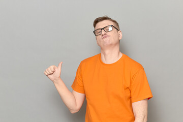 Portrait of funny proud mature man pointing with thumb at himself