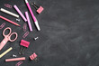 Flat lay pink school supplies on black board background. Top view, overhead. Back to school concept.