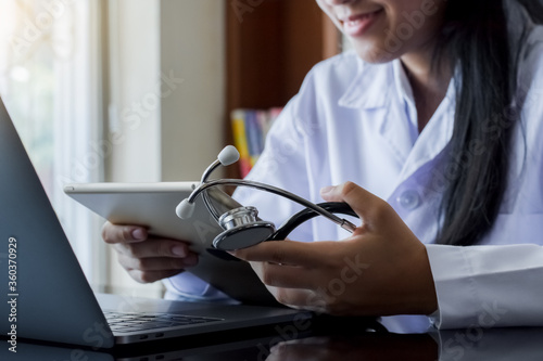 Fotomural Female doctor working on laptop computer.