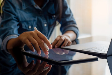 Wall Mural - Close up of female hands working on digital tablet computer.